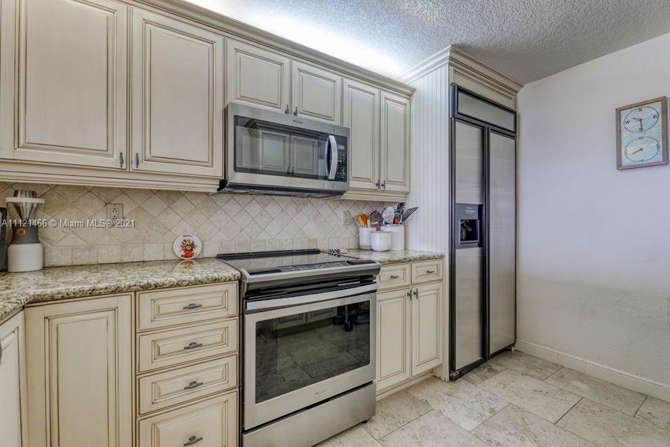 9 Royal Palm Way, Unit 6030 Boca Raton, FL 33432 - Photo 4 of 17 a kitchen with granite countertop white cabinets and stainless steel appliances
