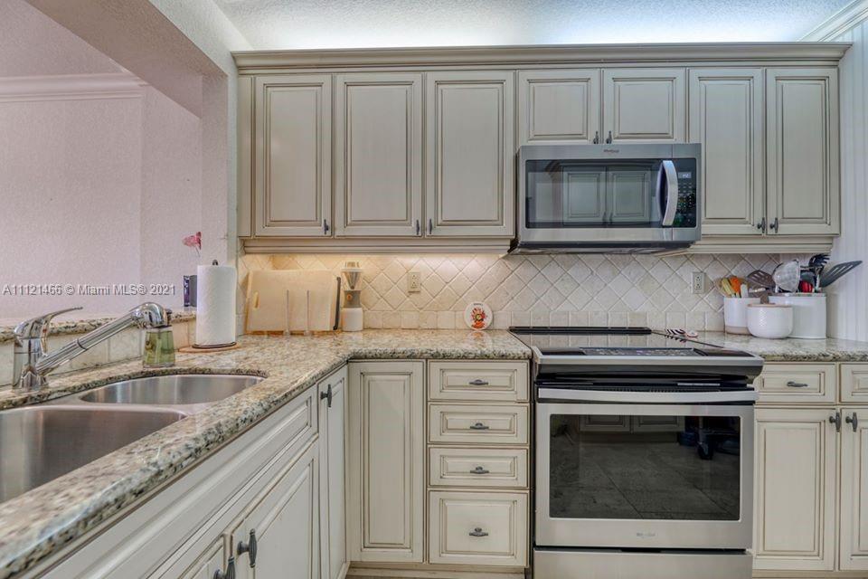 9 Royal Palm Way, Unit 6030 Boca Raton, FL 33432 - Photo 5 of 17 a kitchen with granite countertop white cabinets and stainless steel appliances