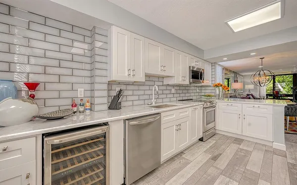 a kitchen with white cabinets appliances and a sink