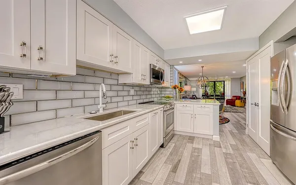 a kitchen with white cabinets appliances and sink