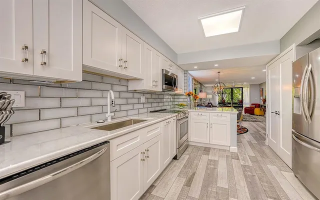 a kitchen with white cabinets appliances and sink