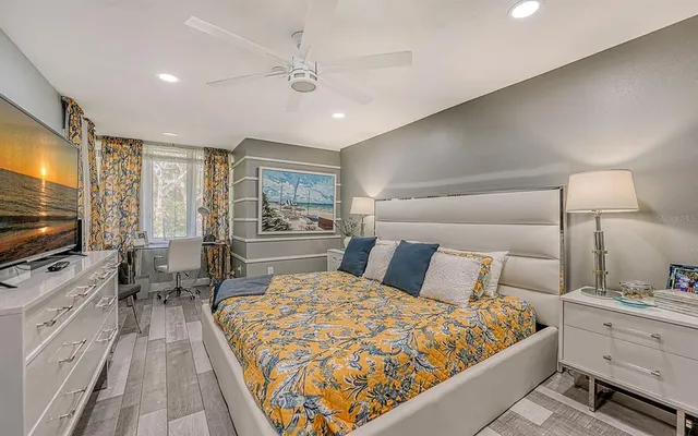 a bed room with a bed television and a large window