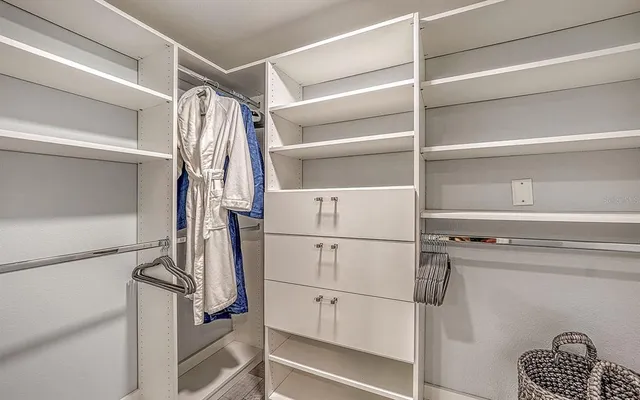 a view of walk in closet with empty racks