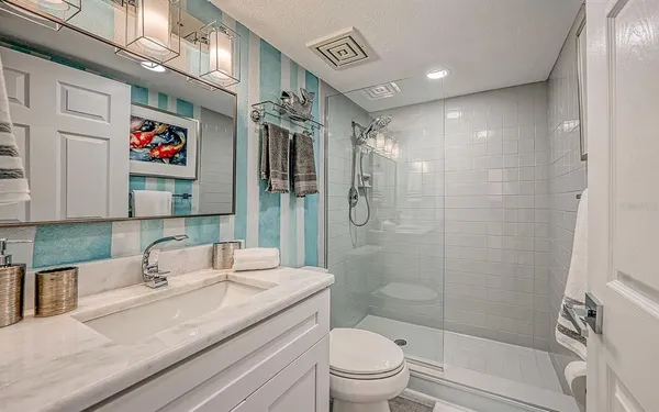 a bathroom with a sink a toilet and shower