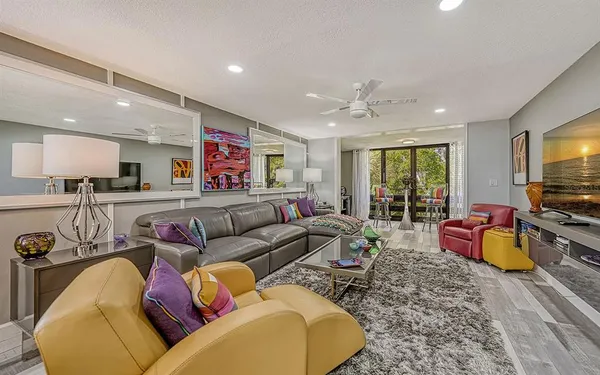 a living room with furniture ceiling fan and a flat screen tv