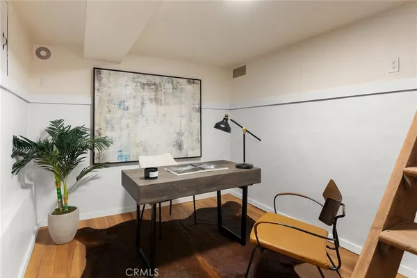 a view of a workspace room with furniture and wooden floor