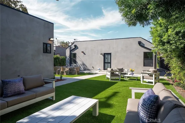 a view of a house with couches chairs and a yard