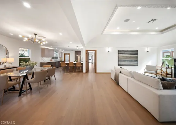 a large white kitchen with lots of furniture and chandelier