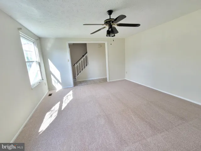a view of a livingroom with a ceiling fan and window