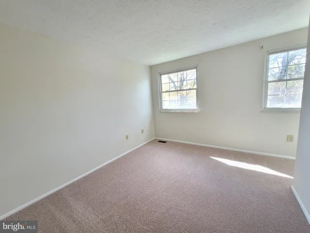 an empty room with a window and a ceiling fan