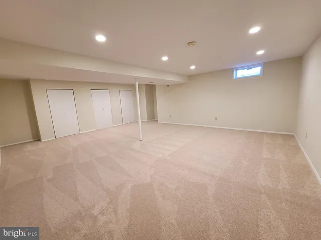 an empty room with a ceiling fan and windows