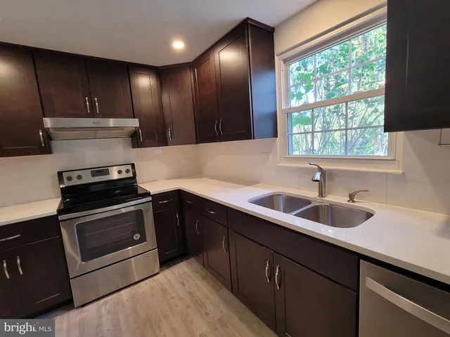 a kitchen with a sink stove and cabinets
