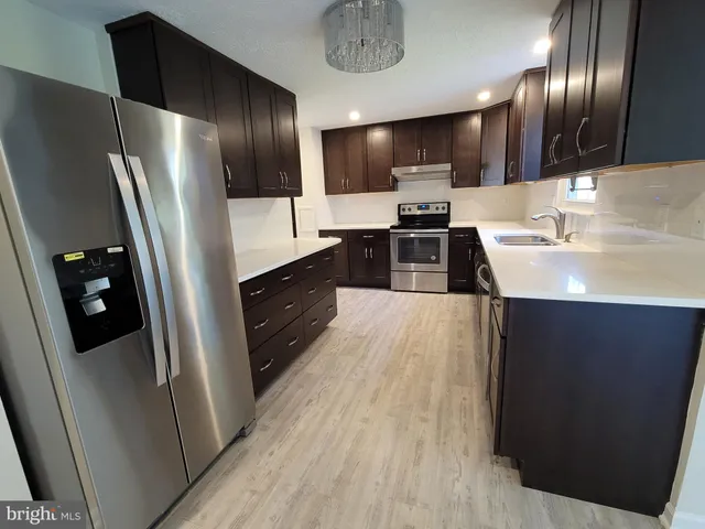 a kitchen with stainless steel appliances a refrigerator a sink a stove a microwave and cabinets