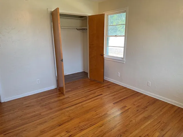 an empty room with wooden floor and a window