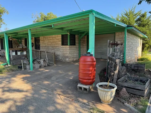 a backyard of a house with barbeque oven table and chairs