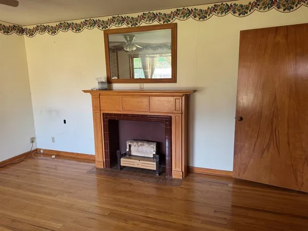 a view of a room with wooden floor and a fireplace