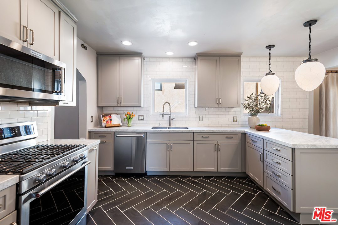 1307 South Rimpau Boulevard Los Angeles, CA 90019 - Photo 13 of 54 a kitchen with a sink stove and microwave
