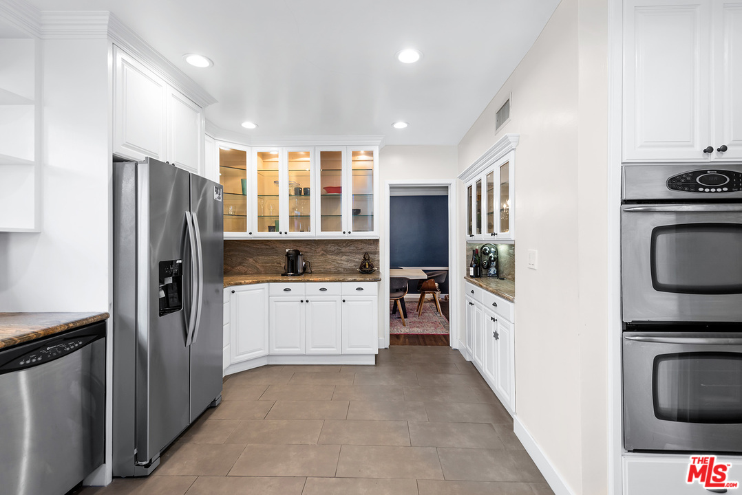 1307 South Rimpau Boulevard Los Angeles, CA 90019 - Photo 33 of 54 a kitchen with a refrigerator and a stove top oven