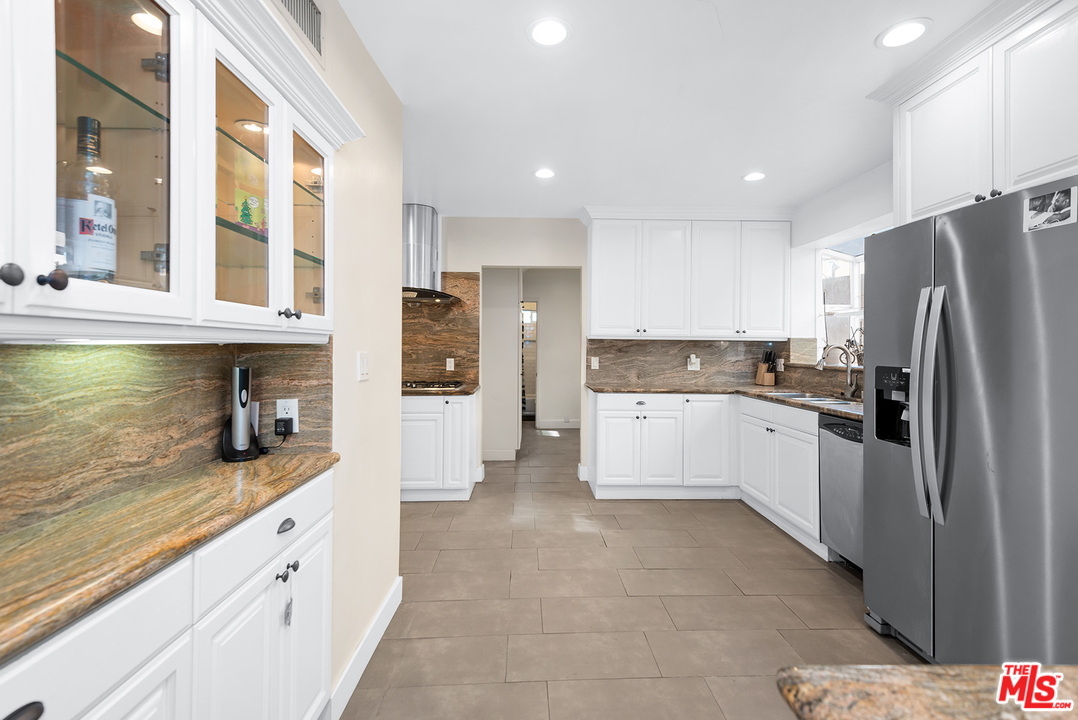 1307 South Rimpau Boulevard Los Angeles, CA 90019 - Photo 34 of 54 a large kitchen with stainless steel appliances granite countertop a refrigerator and a sink