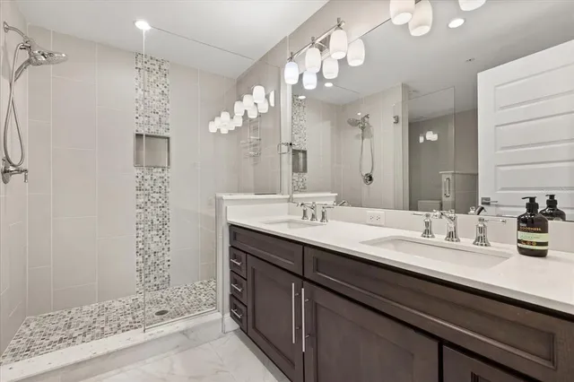 a bathroom with a double vanity sink mirror and shower