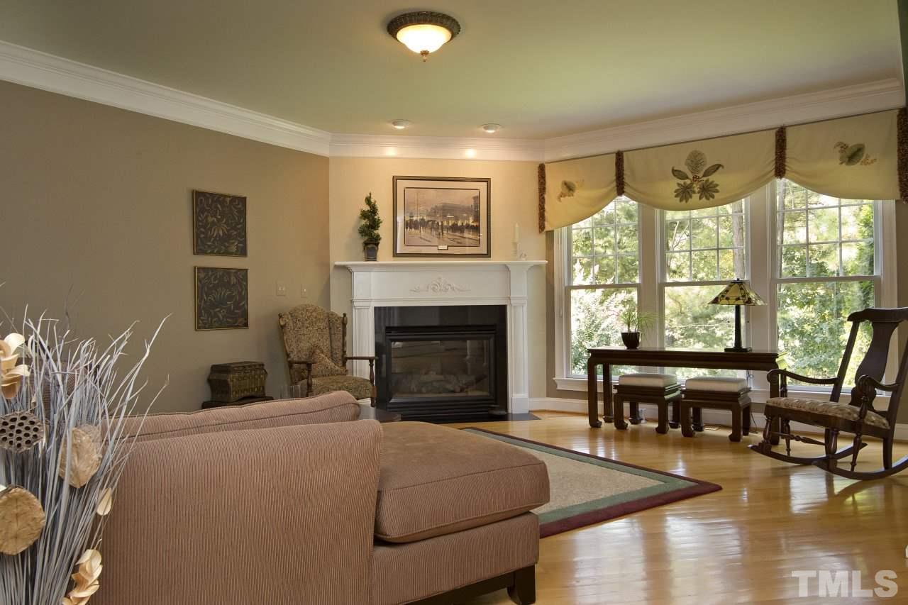 12301 Beestone Lane Raleigh, NC 27614 - Photo 11 of 25 a living room with furniture a fireplace and a floor to ceiling window