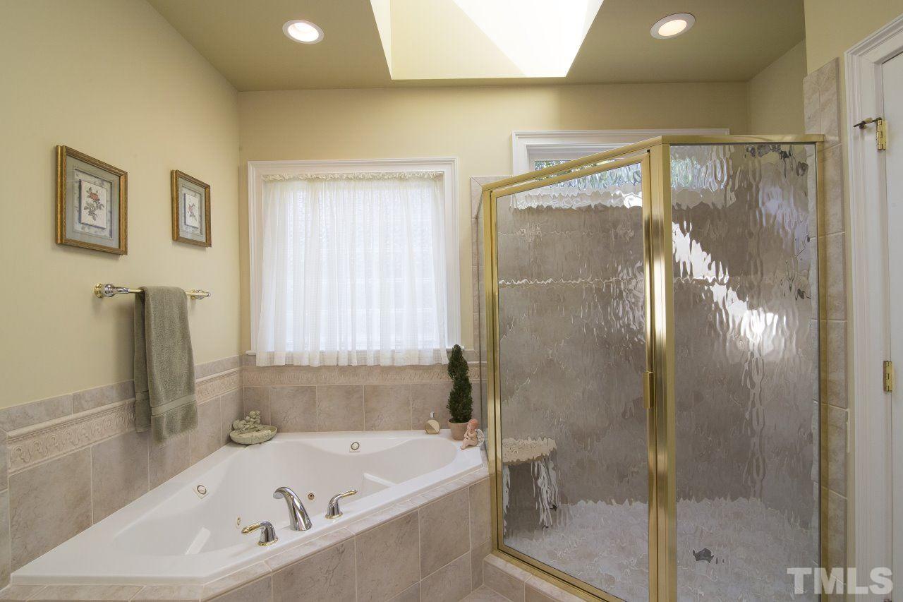 12301 Beestone Lane Raleigh, NC 27614 - Photo 15 of 25 a bathroom with a bathtub and a shower