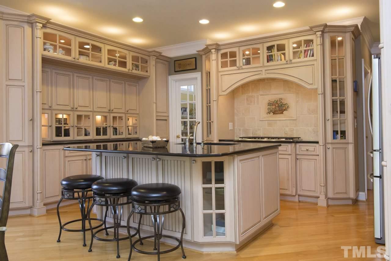 12301 Beestone Lane Raleigh, NC 27614 - Photo 6 of 25 a kitchen with stainless steel appliances granite countertop a table and chairs in it