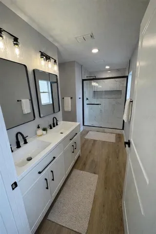 a bathroom with a sink a mirror and shower