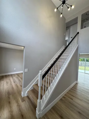 a view of staircase with wooden floor and fan