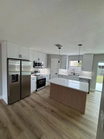 a kitchen with stainless steel appliances a stove top oven and cabinets