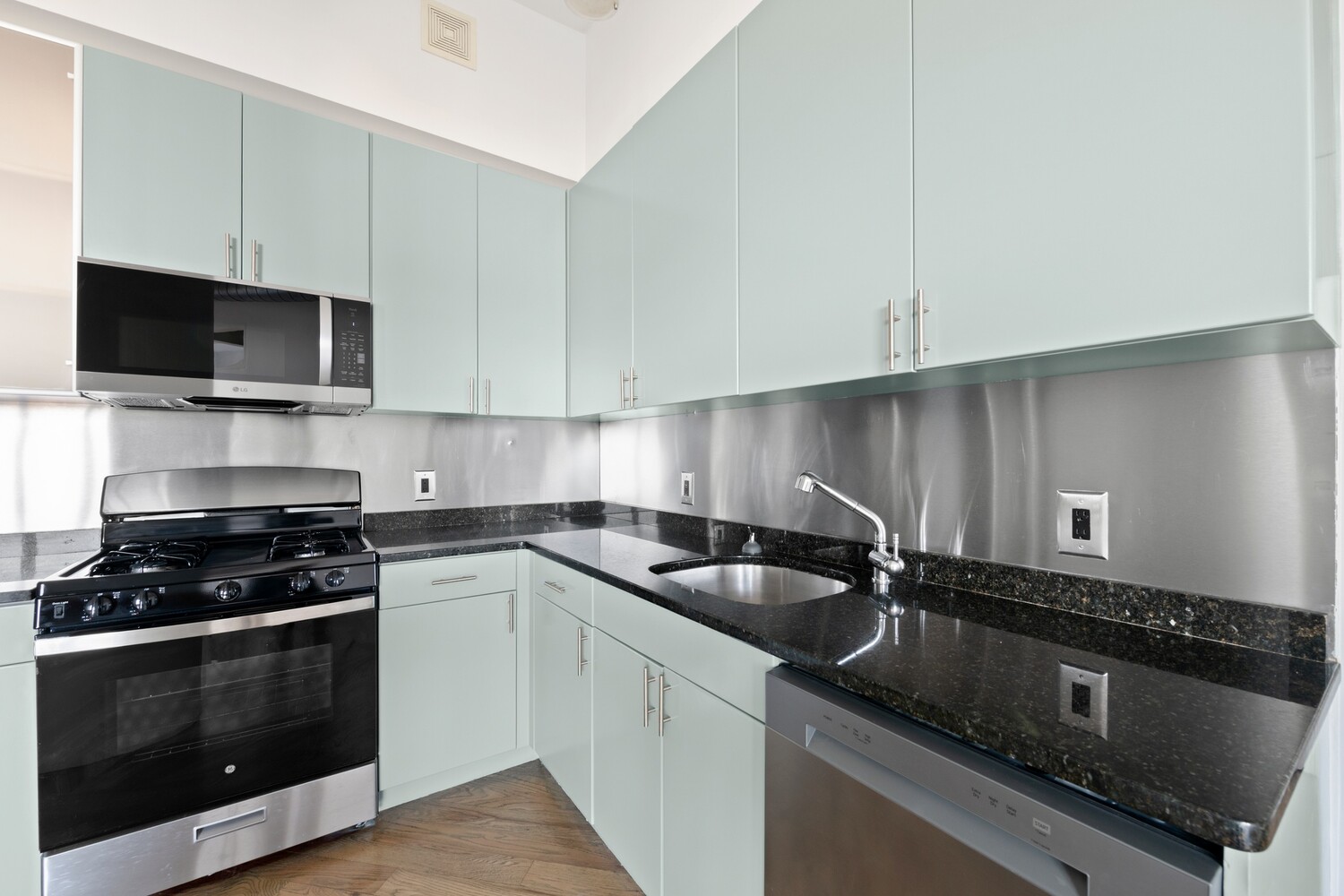 176 Johnson Street, Unit 7C Brooklyn, NY 11201 - Photo 7 of 15 a kitchen with granite countertop a sink a stove and cabinets