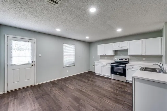 a kitchen with a refrigerator and a stove top oven