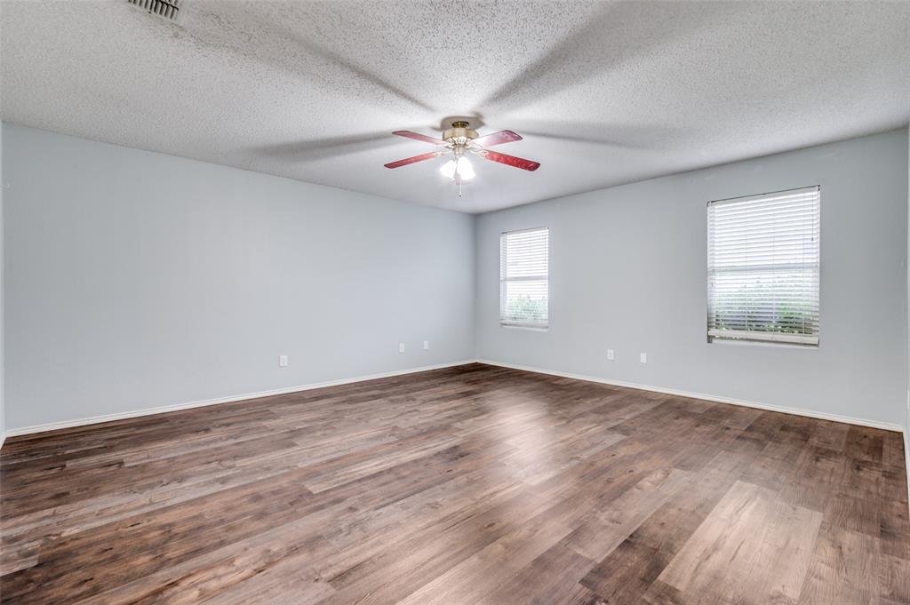 8405 Seven Oaks Lane Denton, TX 76210 - Photo 6 of 11 an empty room with wooden floor fan and windows