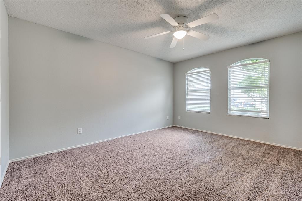 8405 Seven Oaks Lane Denton, TX 76210 - Photo 8 of 11 an empty room with windows and ceiling fan