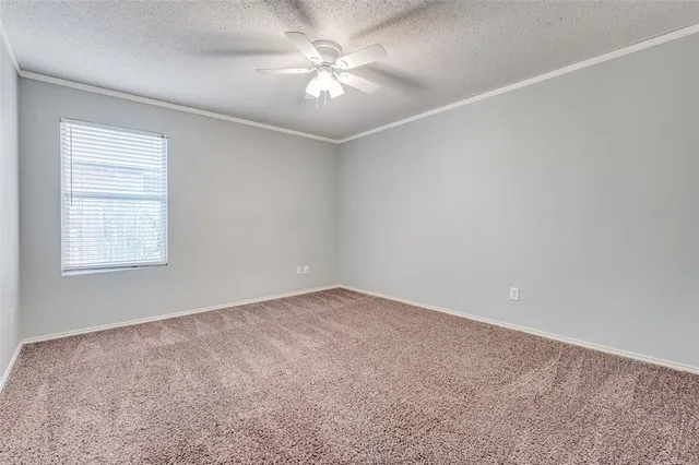 an empty room with windows and ceiling fan