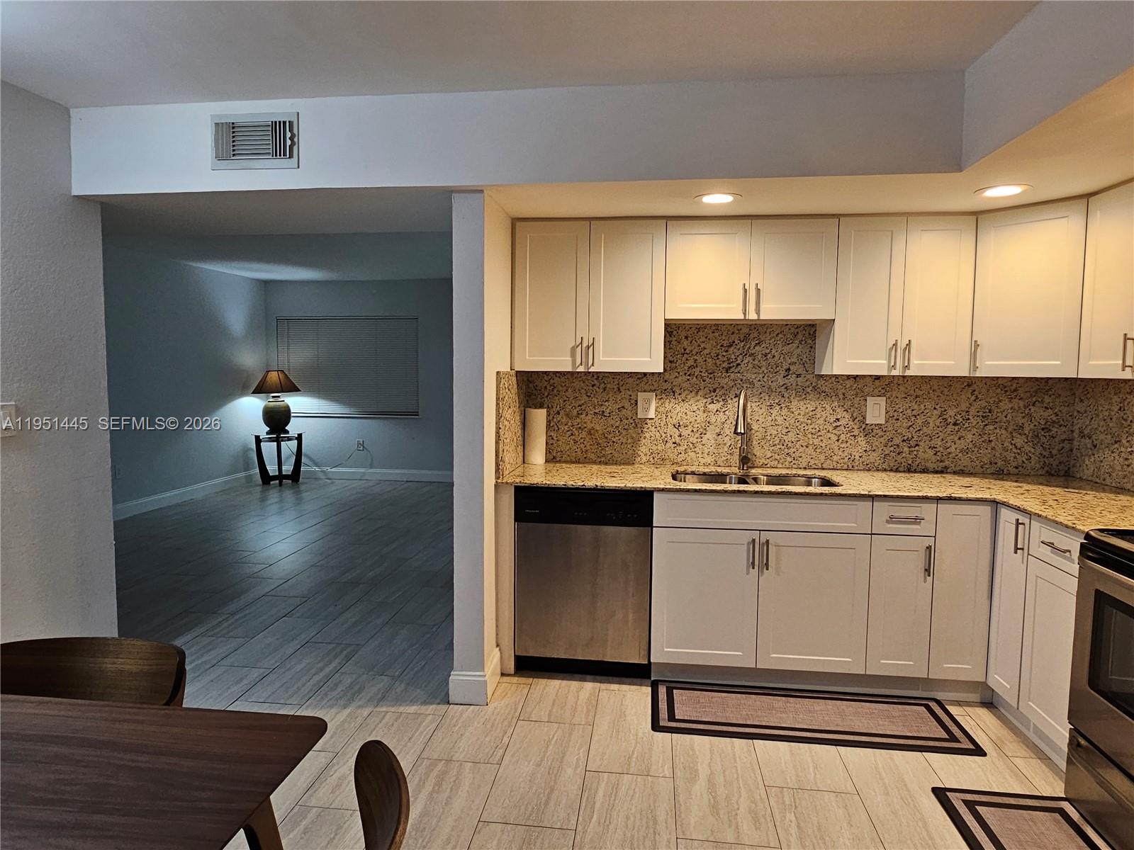 8075 Southwest 107th Avenue, Unit 114 Miami, FL 33173 - Photo 6 of 18 a kitchen with a sink cabinets and wooden floor