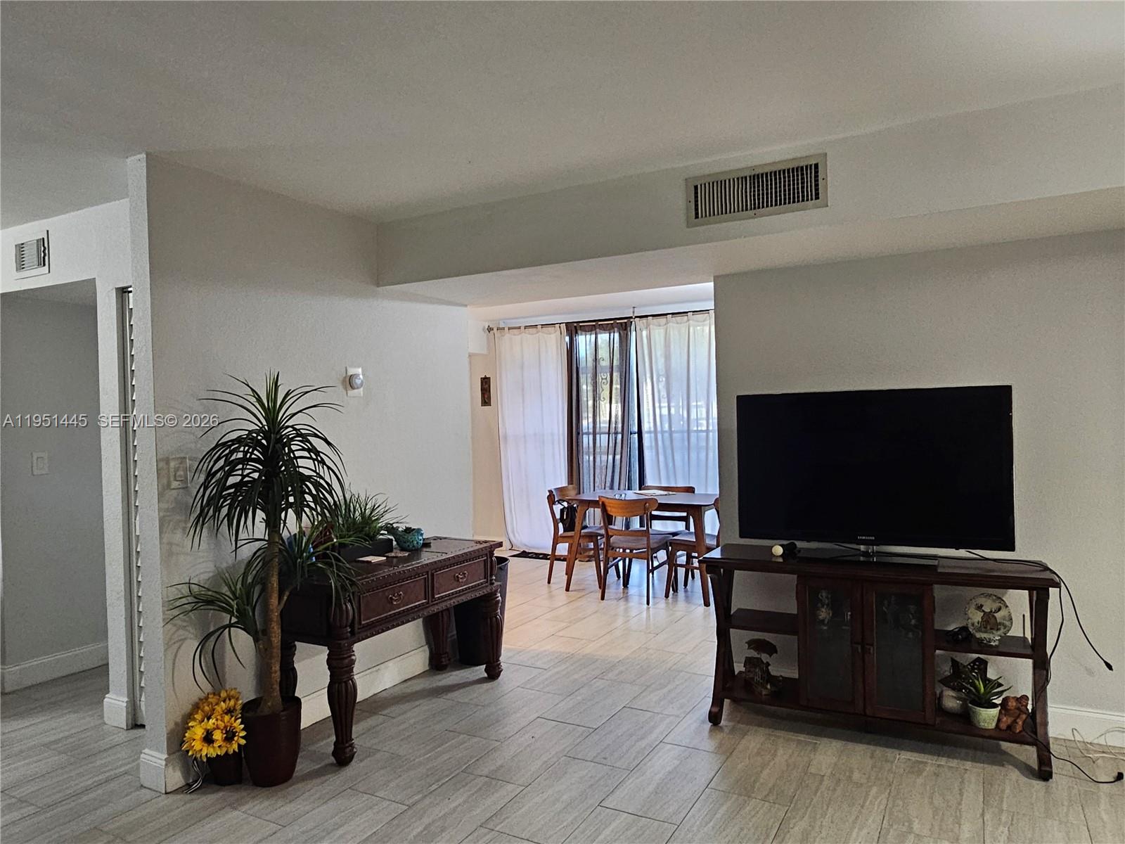 8075 Southwest 107th Avenue, Unit 114 Miami, FL 33173 - Photo 8 of 18 a living room with furniture and a flat screen tv