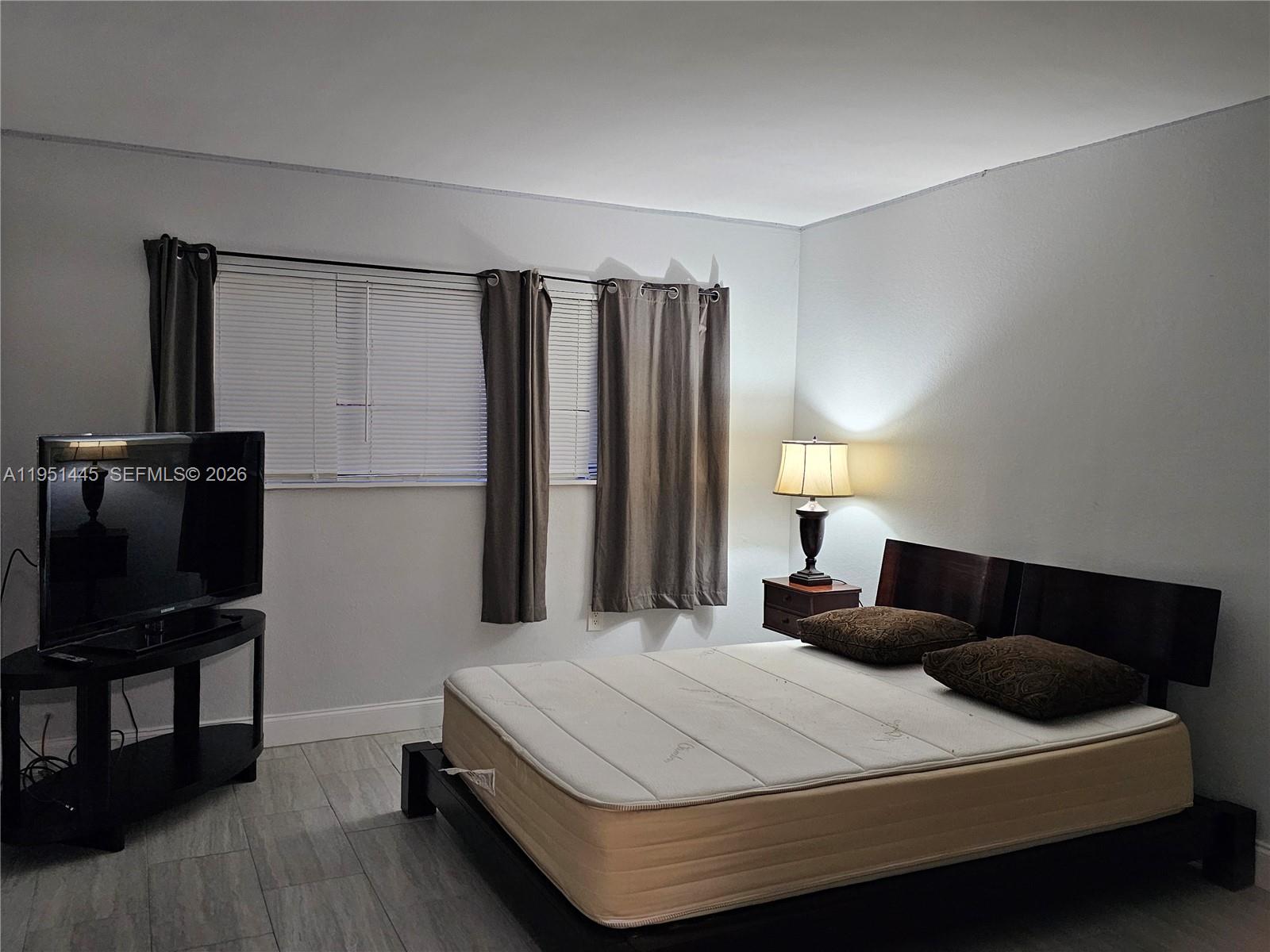 8075 Southwest 107th Avenue, Unit 114 Miami, FL 33173 - Photo 10 of 18 a bedroom with a bed and wooden floor