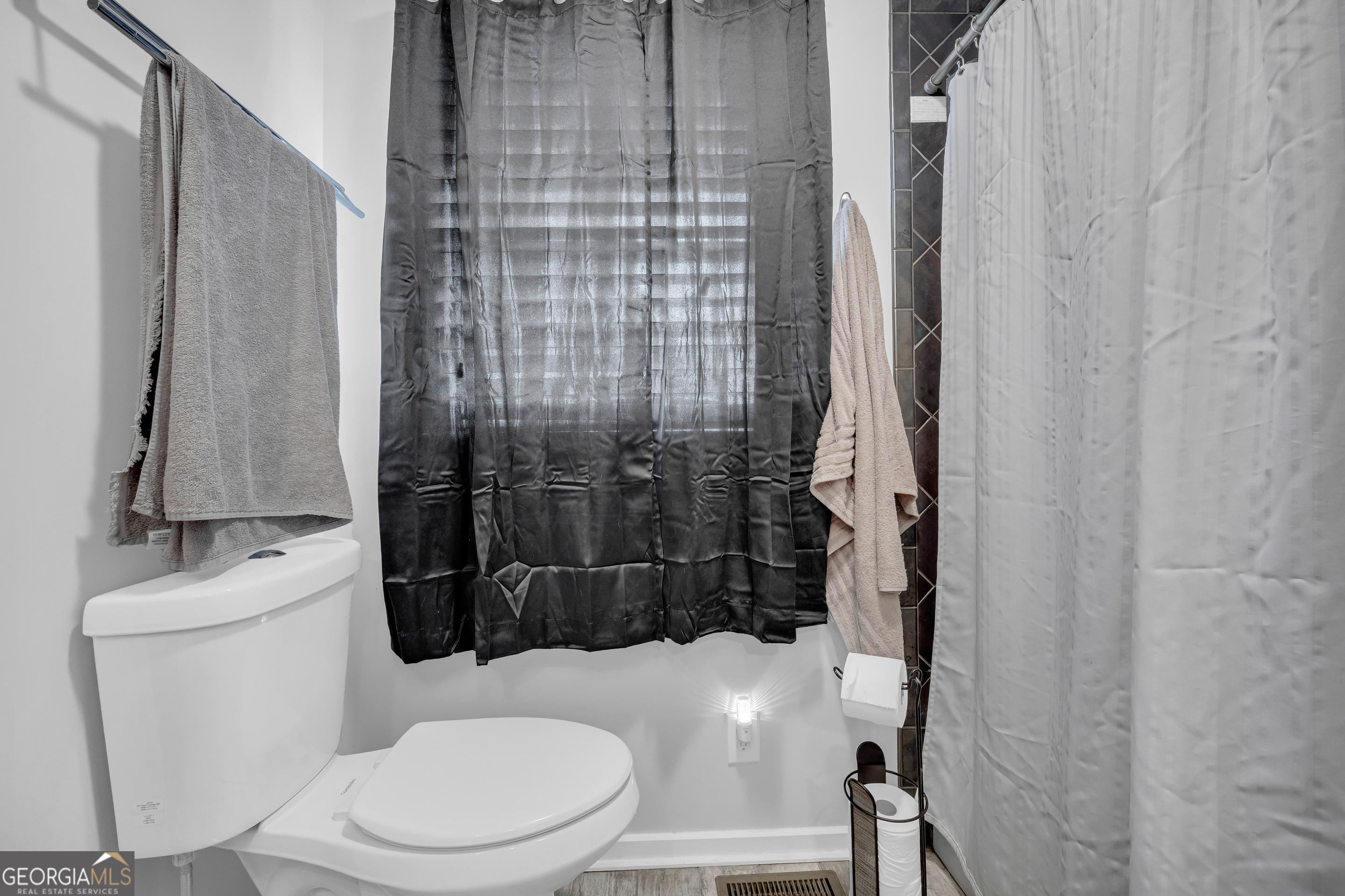 136 Frazier Hill Road Bishop, GA 30621 - Photo 39 of 59 a white toilet sitting next to a shower curtain