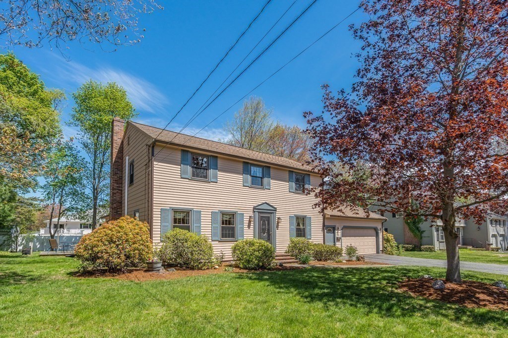 23 Indian Path Dedham, MA 02026 - Photo 1 of 35 a front view of a house with a garden