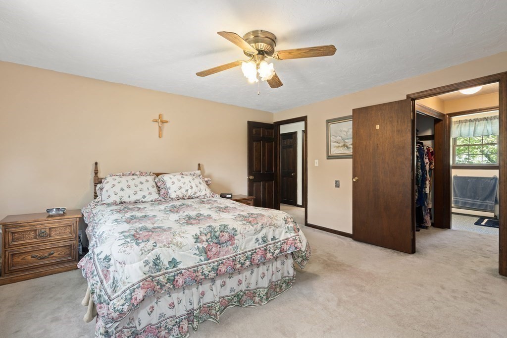 23 Indian Path Dedham, MA 02026 - Photo 17 of 35 a spacious bedroom with a bed and a chandelier