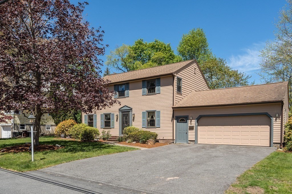 23 Indian Path Dedham, MA 02026 - Photo 2 of 35 a front view of a house with a yard and garage