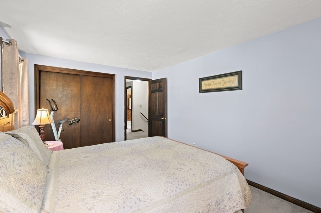 23 Indian Path Dedham, MA 02026 - Photo 22 of 35 a bedroom with a bed and a painting on the wall