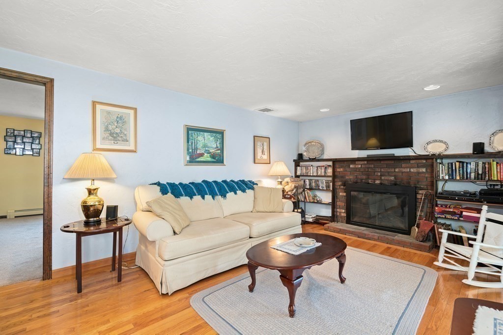 23 Indian Path Dedham, MA 02026 - Photo 3 of 35 a living room with furniture a flat screen tv and a fireplace
