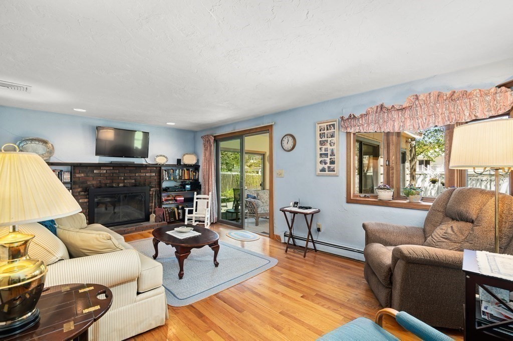 23 Indian Path Dedham, MA 02026 - Photo 4 of 35 a living room with furniture a fireplace and a large window
