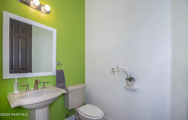 a bathroom with a toilet a sink and mirror