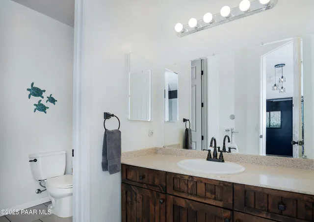 a bathroom with a granite countertop sink a toilet and a mirror