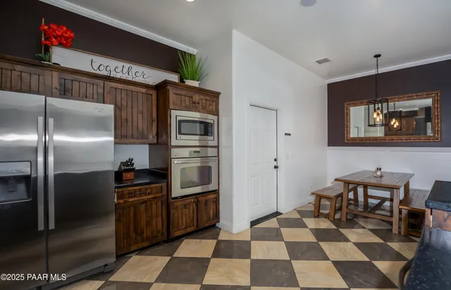 a kitchen with stainless steel appliances granite countertop a refrigerator and a stove top oven