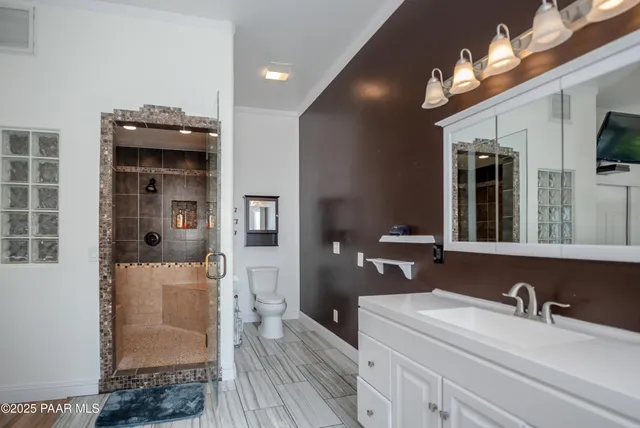 a en suite bathroom with a sink double vanity granite and a mirror