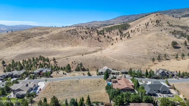 a view of a dry yard with wooden fence